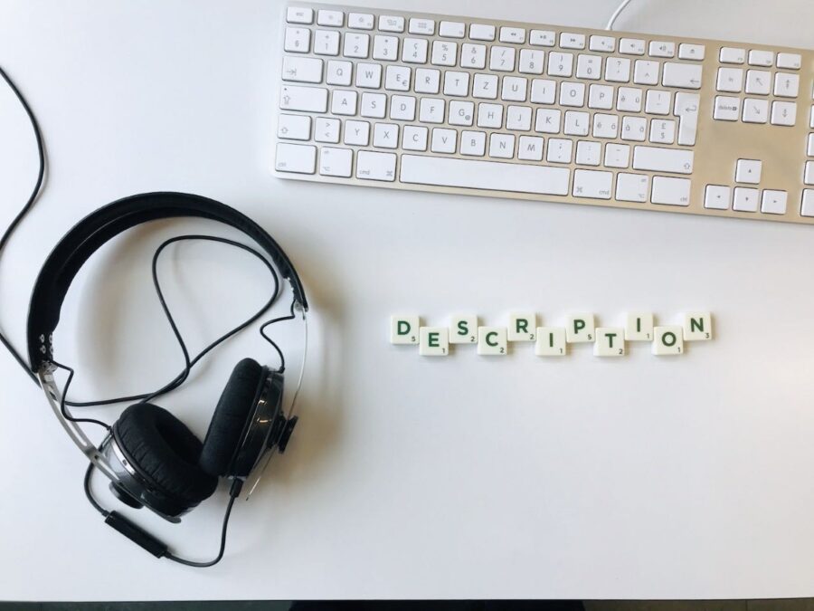 Wir sehen einen Kopfhörer und eine Tastatur, daneben liegen Buchtaben zum Wort "Description" geformt.