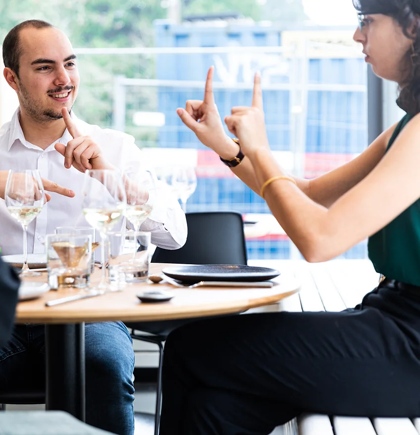 Zwei Personen in einem Restaurant, das Zeichensprache verwendet