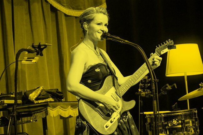 Frölein da Capo am Mikrofon mit Gitarre