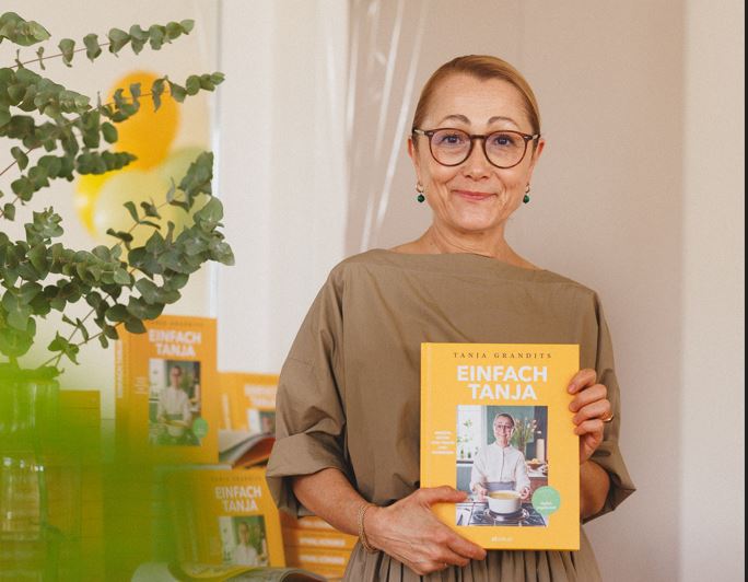 Tanja Grandits an ihrer Buchvernissage im Restaurant Stucki mit ihrem Buch «einfach Tanja» in der Hand.