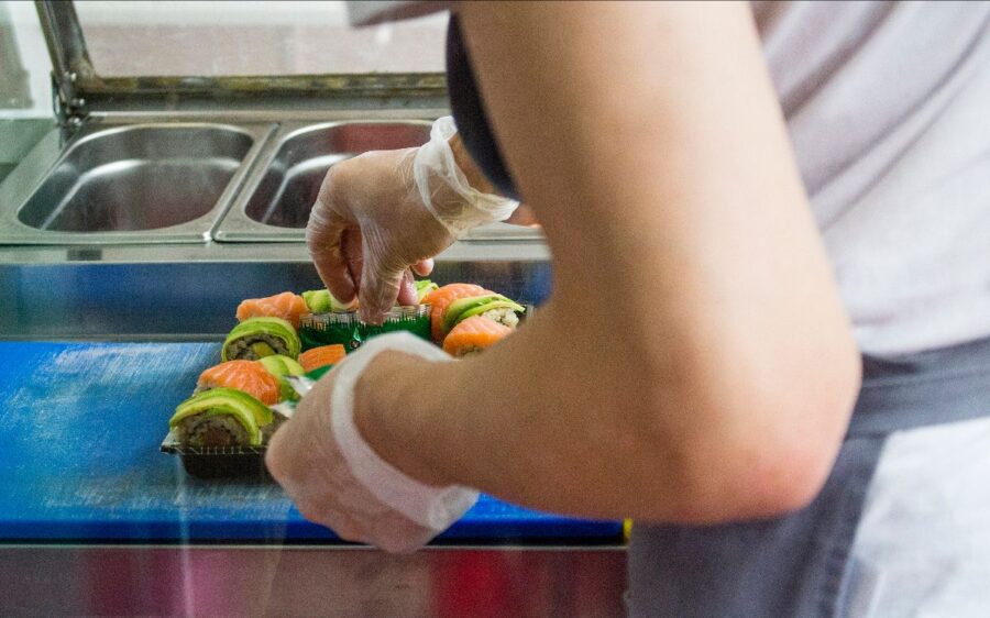 Auf dem Bild sind die Hände und ein Arm einer Frau zu sehen. Sie bereitet gerade eine Mahlzeit zu.