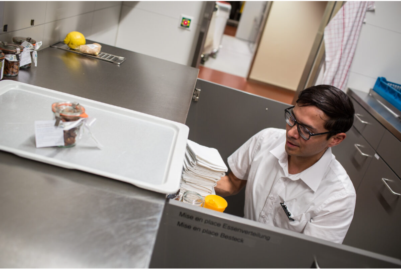 Junger Mann mit Brille in einer Gastronomie-Küche.