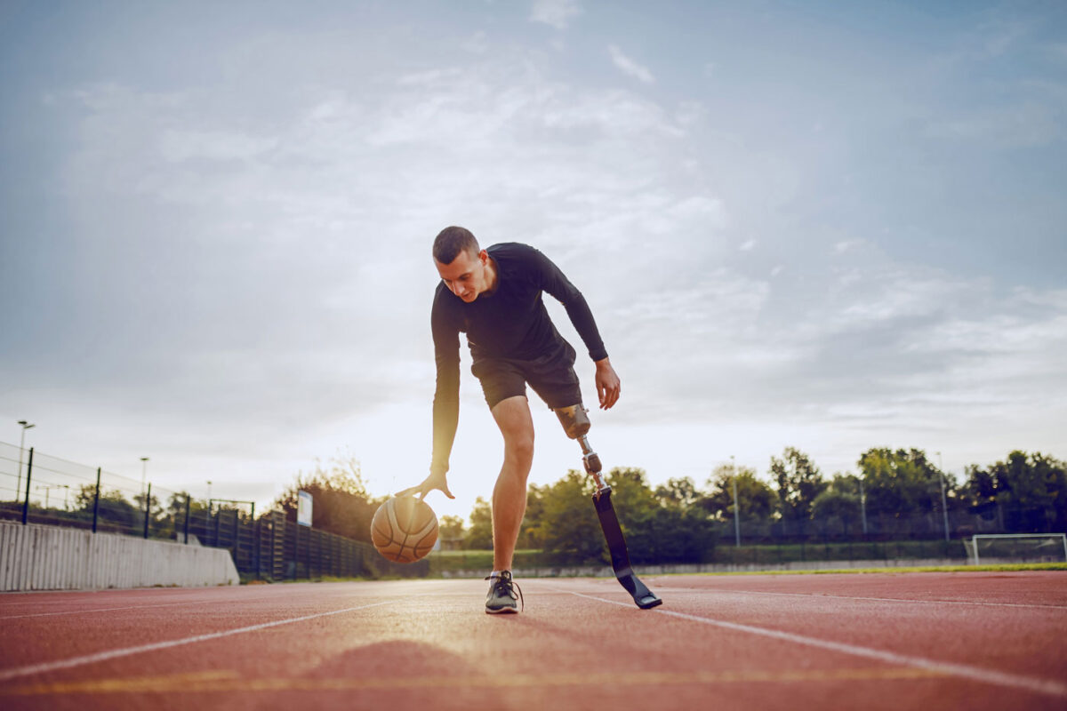Ein Mann mit einer linken Beinprothese spielt Basketball.