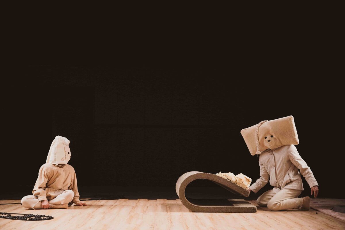Eine Bühne mit zwei Schauspielenden, die verkleidet sind und eine Szene spielen.