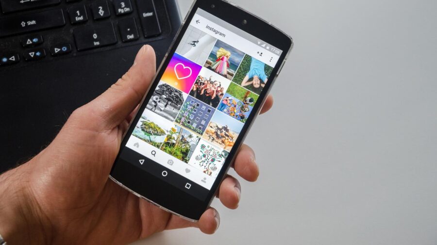 Eine Person hält ein Handy in der Hand und ist gerade auf einen social Media Kanal.