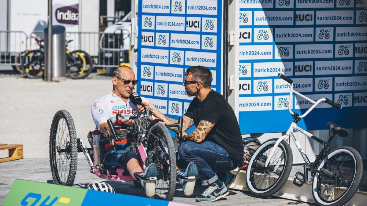 Ein Handbiker wird von einem Moderator interviewt.
