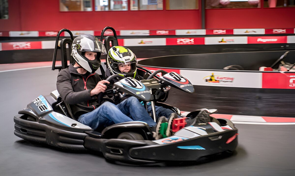 Auf dem Bild sieht man zwei Personen im Kart Doppelsitzer eng um die Kurve fahren.