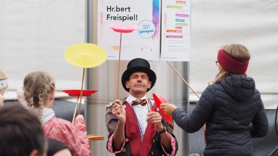 Hr.bert jongliert und übergibt Kindern Jonglierteller.